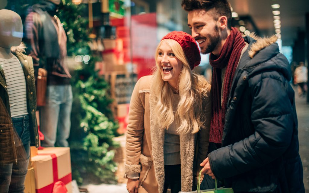 pareja mirando escaparates navideños y haciendo sus compras